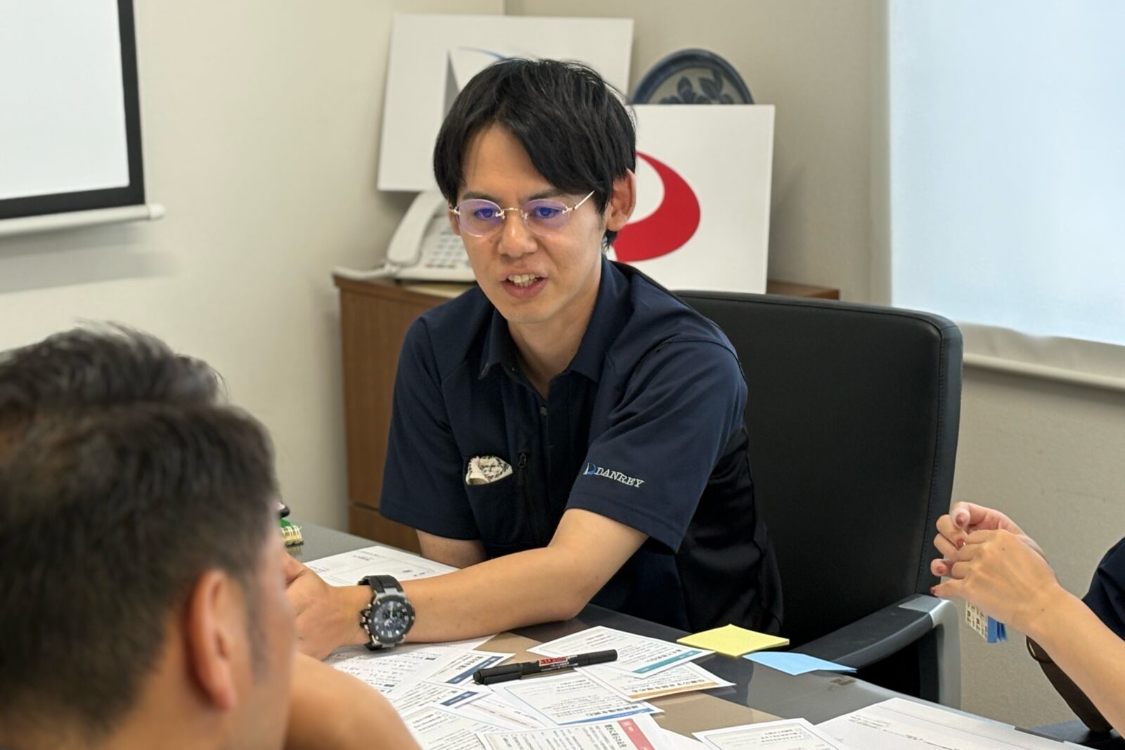 カヤックボンドのメンバーに現場の状況を語る暖冷工業の社員